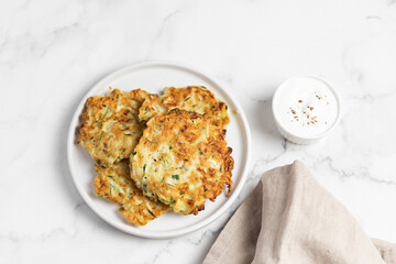 vegetarian zucchini fritters, light marble background