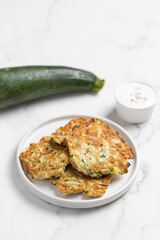 vegetarian zucchini fritters, light marble background