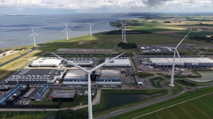 Wind turbines at a data center in Eemshaven, Groningen, The Netherlands. AI, cloud, server infrastructure, and renewable energy. Aerial view. - Powered by Adobe