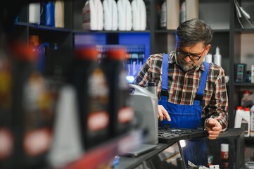 Salesman showing car part to customer in auto parts store