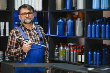 Salesman holding lug wrench in auto parts store