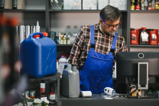 Salesman working at the auto parts store using computer