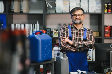 Salesman smiling with crossed arms in auto parts store