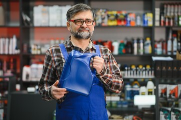 Salesman holding engine oil in auto parts store