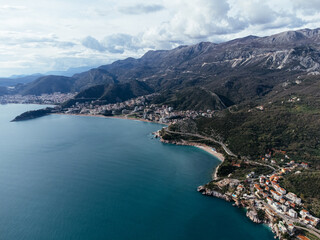 Aerial view of island hotel connected by causeway to coastal village in Montenegro on Adriatic Sea. c.