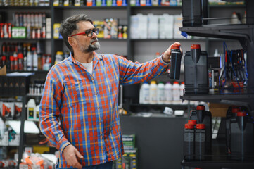 Customer choosing motor oil in auto parts store