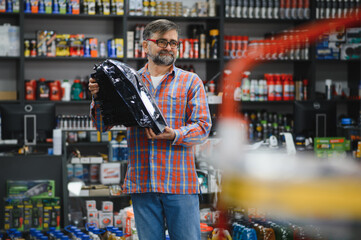 Salesman holding car headlight in auto parts store