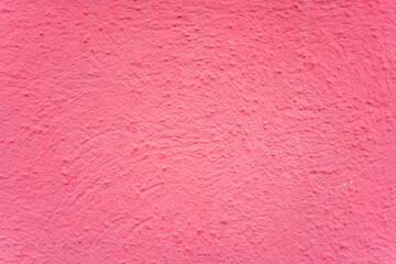 Vibrant textured wall with a playful pink hue exuding warmth and creativity