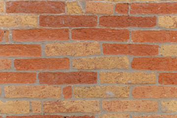 Fototapeta premium Brick wall with warm hues and textured patterns enhances urban charm