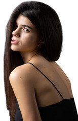 Obraz premium Classic studio portrait of a young brunette dressed in a black top, who is sitting on a chair against a black background.