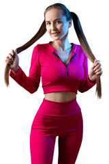 A young healthy girl in a sports top and leggings poses in the studio against a black background.