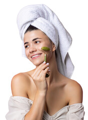 A beautiful cheerful attractive girl with a towel on her head holds a cosmetic roller near her face...