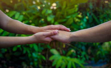 Man hand as lending a helping hand as trust together with compassion concept as lens flare scene at...