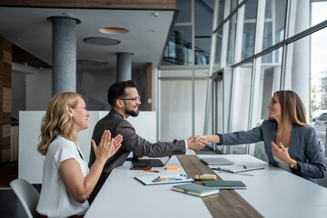 Business people shaking hands congratulating on successful deal in office meeting