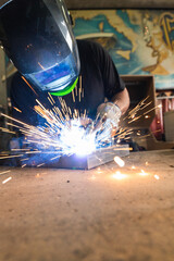 Workers wearing industrial uniforms and Welded Iron Mask at Steel welding plants, industrial safety first concept