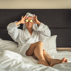 young woman getting eye nature treatment by cucumber at luxury spa resort. Wellness and healing...