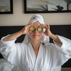 young woman getting eye nature treatment by cucumber at luxury spa resort. Wellness and healing...