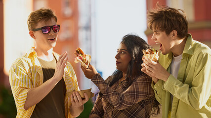 Young man refusing food offered by female friend while laughing outside. Concept of group eating...