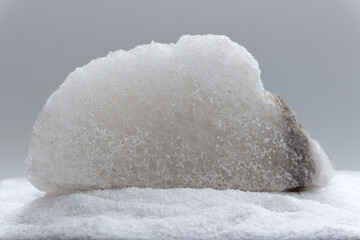 Rock salt laying on pile of iodized salt. Version III.