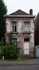 The facade of an old, abandoned, and derelict brick house in a city