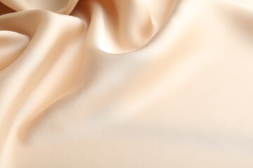 Crumpled beige silk fabric as background, above view. Space for text