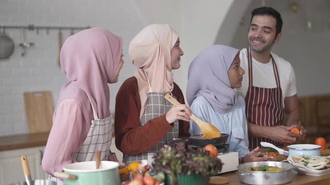 Muslim family cooking together in kitchen preparing food with fresh vegetables, islamic holiday gathering with fresh ingredients and family love, halal food preparation for ramadan or eid celebration