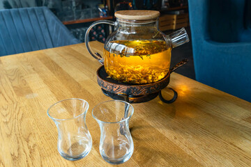 Golden hour tea ritual featuring herbal tea in a glass teapot symbolizing harmony warmth and shared...