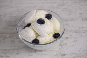 Creamy ice cream with blueberries in a glass bowl
