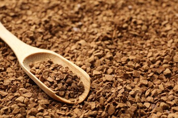 Spoon with aromatic instant coffee as background, closeup