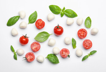 Tasty mozzarella cheese balls, tomatoes, basil and peppercorns on white background, flat lay
