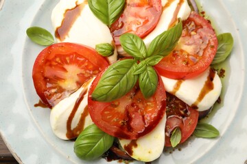 Tasty salad Caprese with mozzarella, tomatoes, basil and spices on table, top view