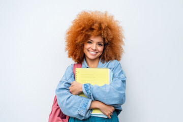 Smiling portrait of latin teenage female student girl with curly afro hairstyle holding backpack...