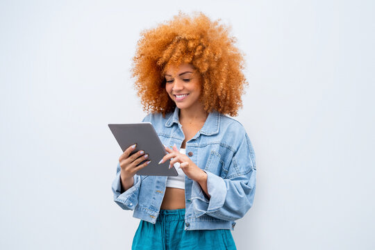 Young afro hairstyle woman holding digital pad computer isolated. 20s African American female student girl working online using web application app on tablet for elearning, studying, communicating.