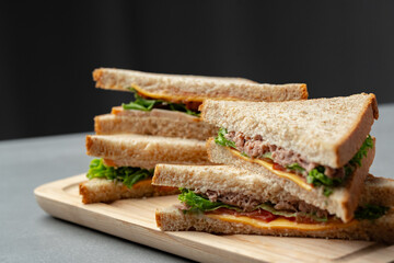 Delicious sandwiches stacked on a wooden platter with fresh ingredients prepared for a light meal