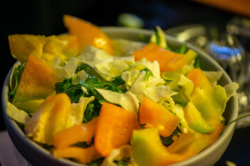A vibrant kitchen scene of a woman slicing cucumbers, lettuce, and other vegetables, capturing the freshness and healthiness of a homemade salad in progress.