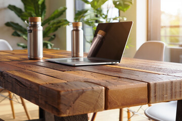 Rustic wooden table with laptop and water bottles image