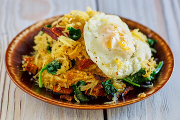 spaghetti squash breakfast scramble with bacon, hash browns, and sautéed spinach