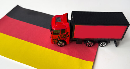 Mini toy at table with blurred background. Industrial shipping concept. toy truck, germany flag