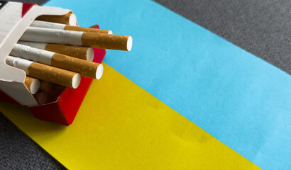 Cigarettes, and flag of Ukraine. Top view. Justice and Tobacco law. Tobacco control act. Government duty. Illegal import