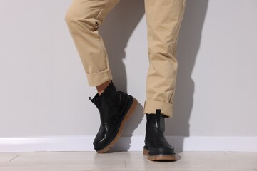Man wearing pair of boots indoors, closeup