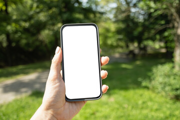 Womans hands with smartphone in outdoor green setting. Check apps, focused on device, chatting,...