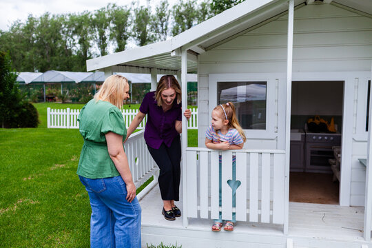 Speech therapist professional with girl interacting by cubby house talking and assessing child