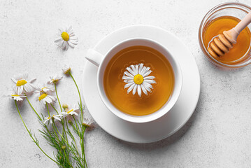 Chamomile tea cup with honey and chamomile flowers