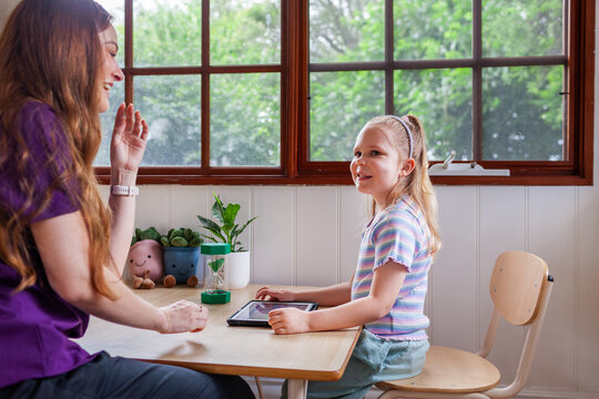 Speech therapist professional with child using technology to help with language development