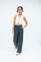 A bold and fierce young Asian woman walking forward with confidence, one hand tucked in her pocket....