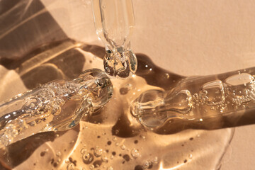 Droppers with essential oil, serum on beige background, top view.