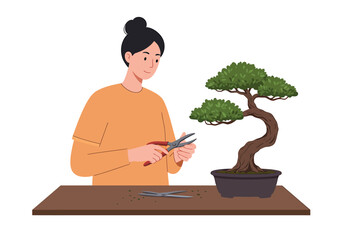 A smiling woman with her hair in a bun carefully prunes a lush green bonsai tree with shears at a wooden table.