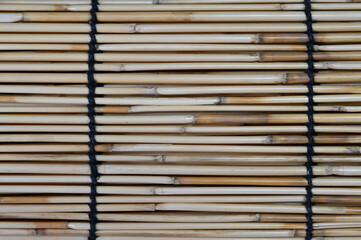 Close-up of bamboo screen mat texture with black binding cords