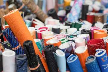 Colorful rolls of textured materials stacked together in a creative workspace for crafting projects