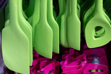 Colorful kitchen utensils in vibrant green and pink hues arranged for culinary creativity